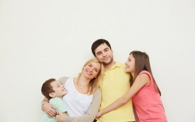 Portrait of affectionate family of four posing over white background